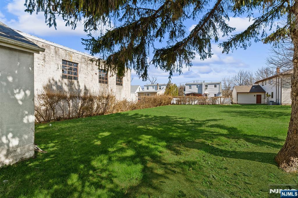 255 Garibaldi Avenue Lodi, NJ 07644 - Photo 29 of 34 a view of a white house with a big yard plants and large trees