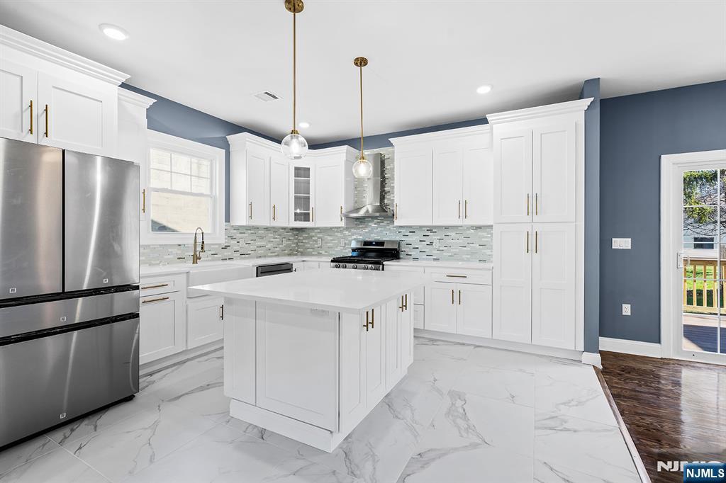 255 Garibaldi Avenue Lodi, NJ 07644 - Photo 9 of 34 a kitchen with white cabinets and stainless steel appliances