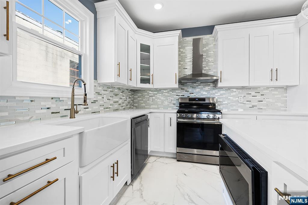 255 Garibaldi Avenue Lodi, NJ 07644 - Photo 10 of 34 a kitchen with stainless steel appliances a stove sink and cabinets