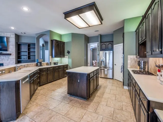a kitchen with stainless steel appliances granite countertop a stove a sink dishwasher a refrigerator and a oven