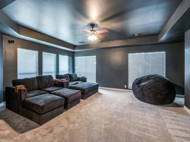 a living room with furniture and a ceiling fan