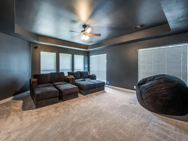 a living room with furniture and a ceiling fan