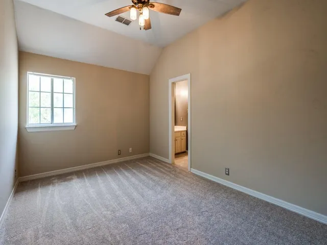 an empty room with chandelier fan