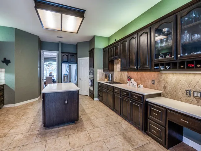 a large kitchen with stainless steel appliances granite countertop a sink counter space cabinets and a large window