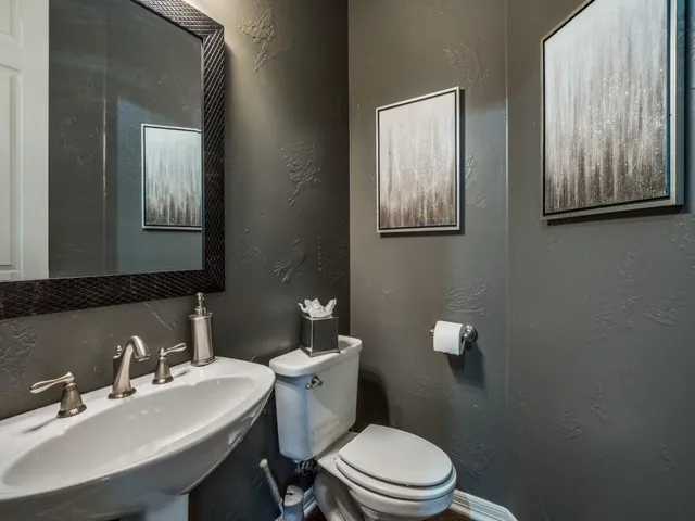 a bathroom with a toilet a sink and mirror