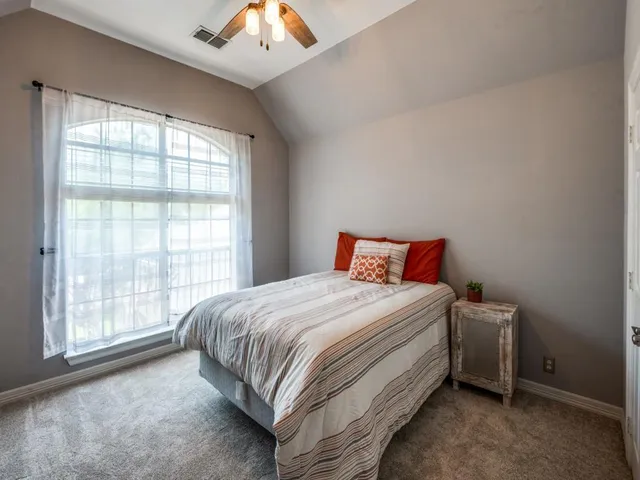 a bed sitting in a bedroom next to a window