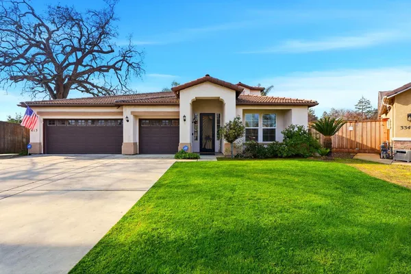 a front view of a house with a garden and yard