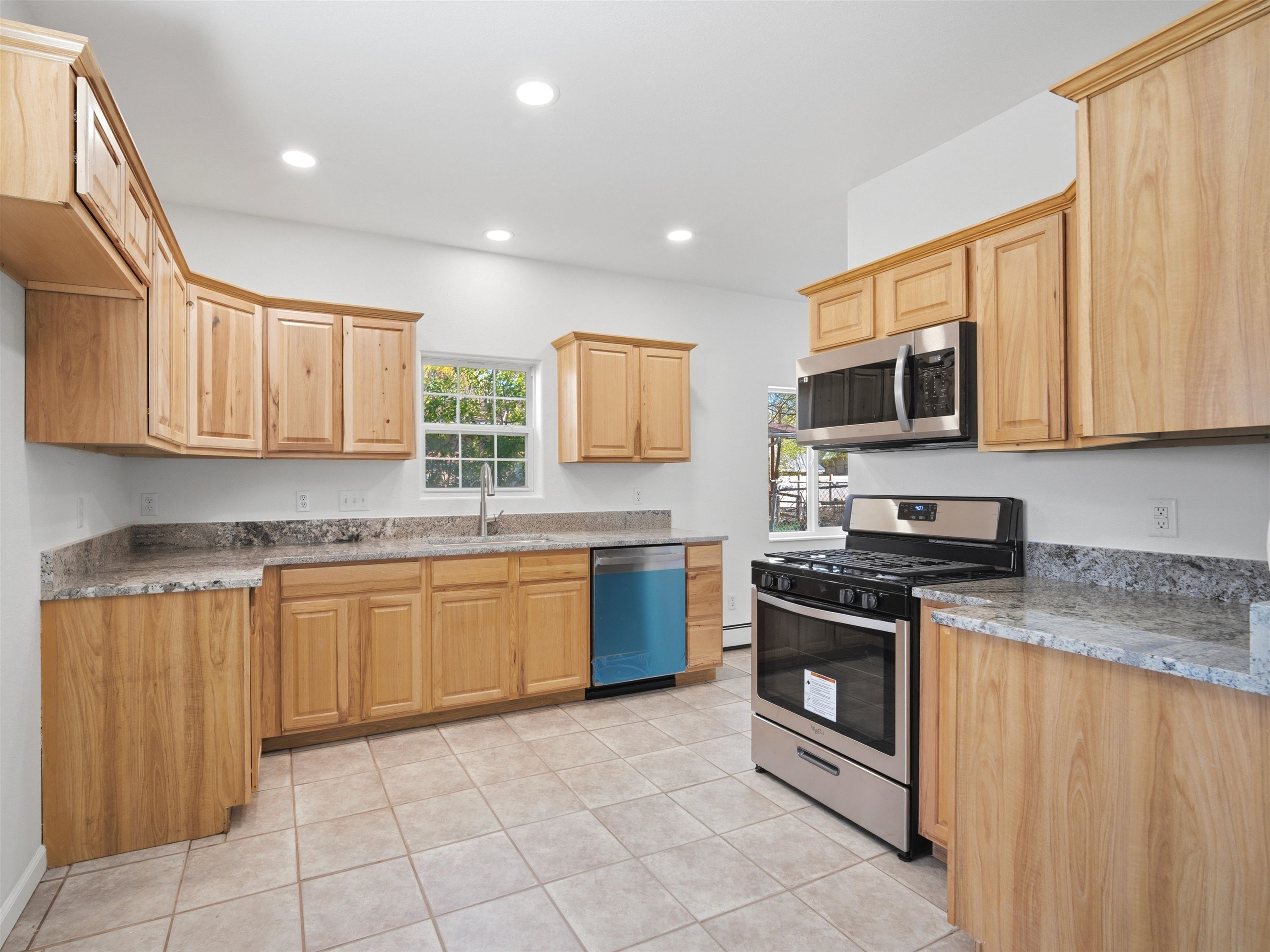 252 South Peach Street Fruita, CO 81521 - Photo 8 of 22 a kitchen with stainless steel appliances granite countertop a stove top oven a sink dishwasher and a microwave oven on the blue kitchen countertops