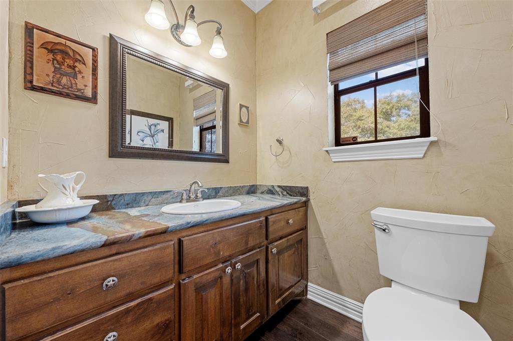 1125 Whispering Oaks China Spring, TX 76633 - Photo 12 of 39 Bathroom featuring vanity, dark wood-style flooring, and a textured wall
