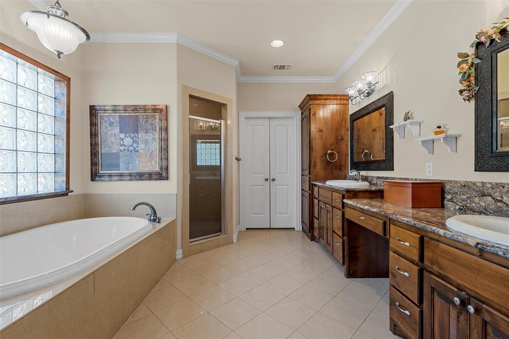 1125 Whispering Oaks China Spring, TX 76633 - Photo 16 of 39 Bathroom with light tile patterned floors, crown molding, a garden tub, double vanity, and a shower stall