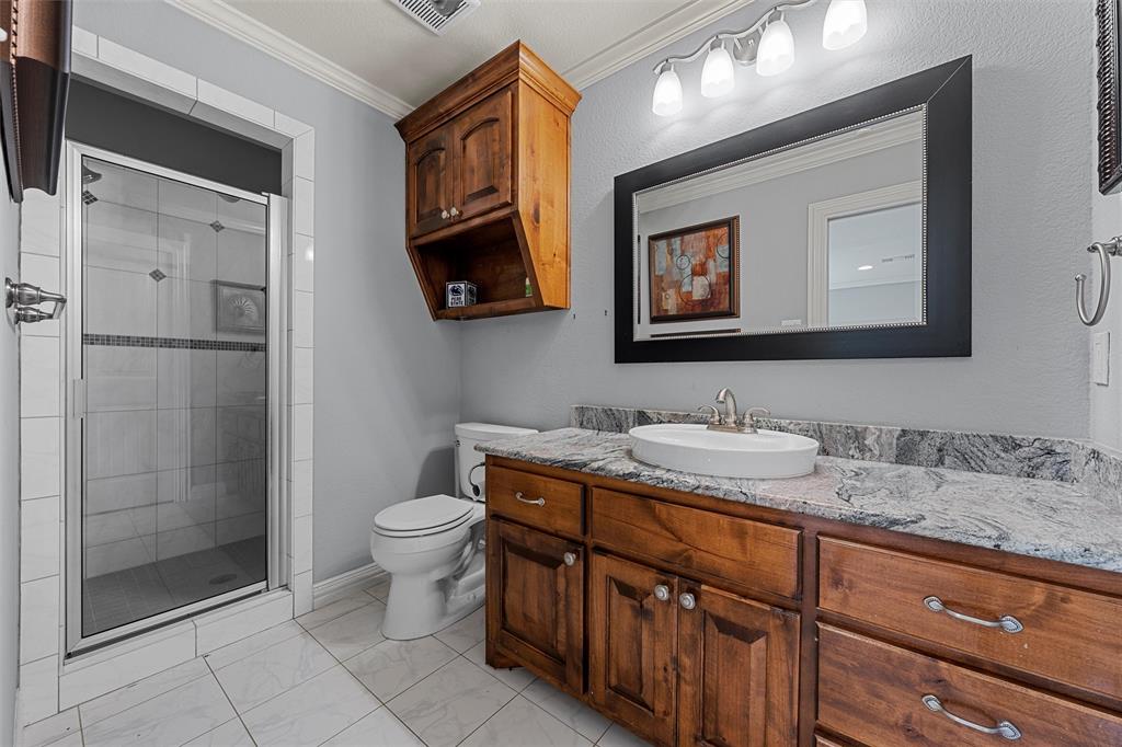 1125 Whispering Oaks China Spring, TX 76633 - Photo 27 of 39 Bathroom featuring crown molding, vanity, a shower stall, and light marble finish flooring