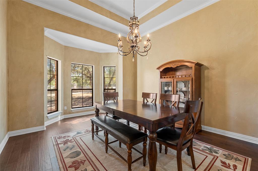 1125 Whispering Oaks China Spring, TX 76633 - Photo 5 of 39 Dining space with crown molding, hardwood / wood-style floors, a chandelier, a tray ceiling, and a textured wall