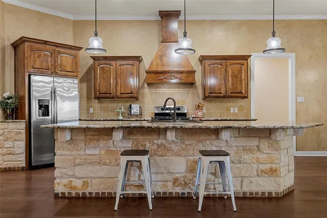 a kitchen with stainless steel appliances granite countertop a sink a stove and a wooden floors