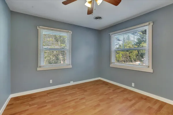 a view of a kitchen with white cabinets and wooden floor