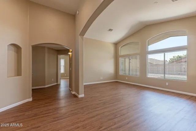 a view of an empty room with glass door and wooden floor