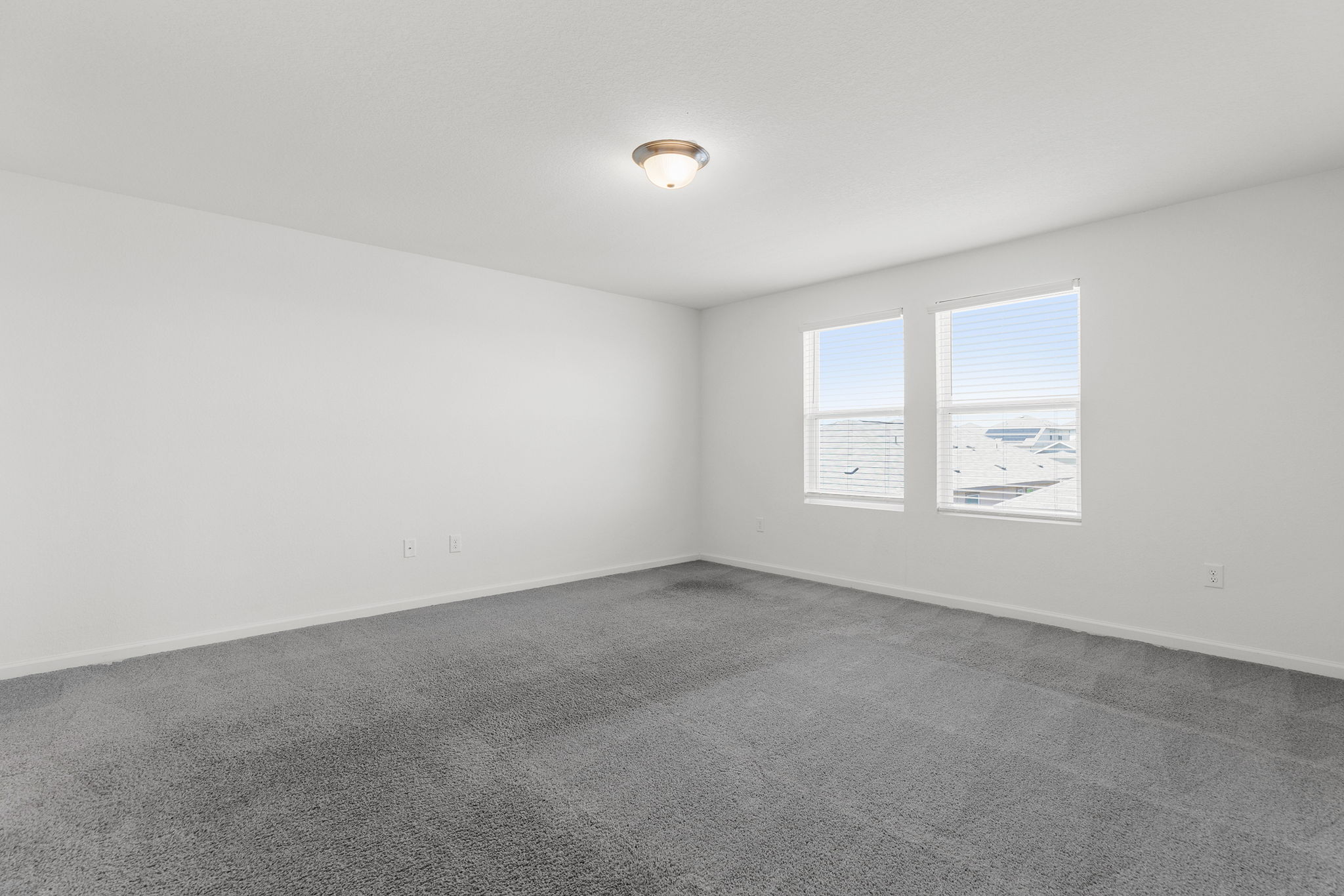 409 Line Of Fire Way Jarrell, TX 76537 - Photo 17 of 30 Spacious room featuring light gray carpeting, white walls, baseboard trim, and open wall space for flexible furniture placement.