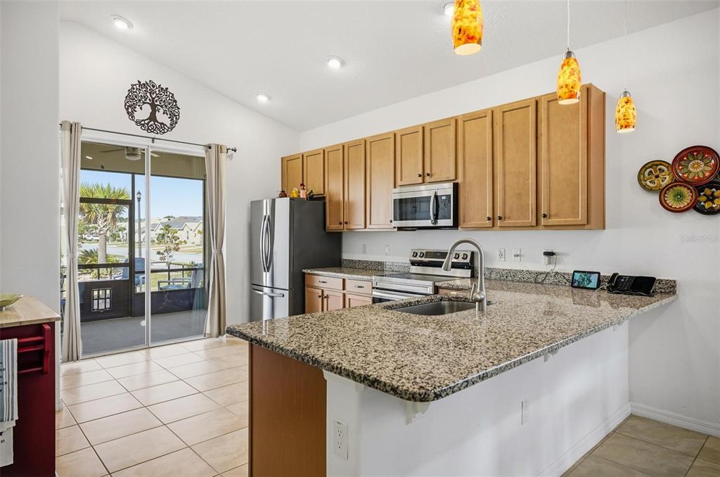 2 Tideway Trail Palm Coast, FL 32137 - Photo 11 of 34 a kitchen with stainless steel appliances granite countertop a sink dishwasher stove and refrigerator with wooden floor