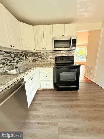 a kitchen with granite countertop a sink and cabinets