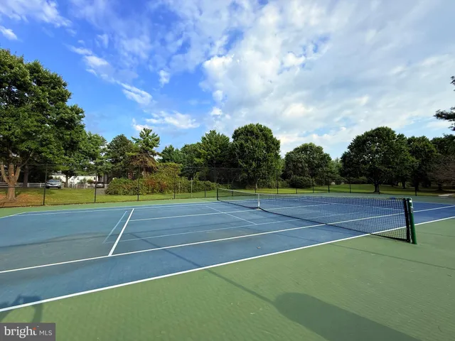 a view of a sign board with garden and trees