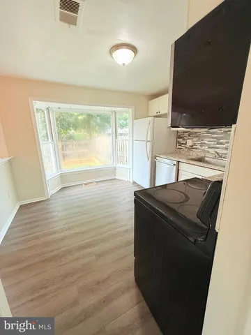 a kitchen with granite countertop a stove and cabinets