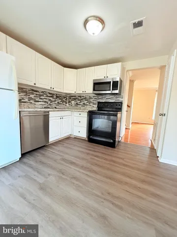 a kitchen with stainless steel appliances granite countertop a stove a refrigerator and a microwave