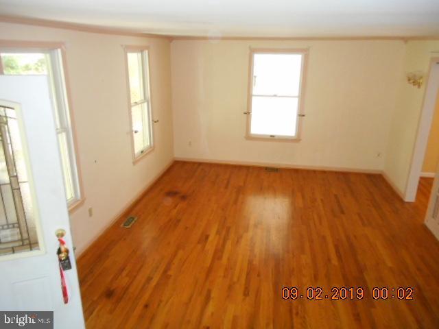 1520 Old Plum Point Road Huntingtown, MD 20639 - Photo 3 of 14 a view of an empty room with wooden floor and a window