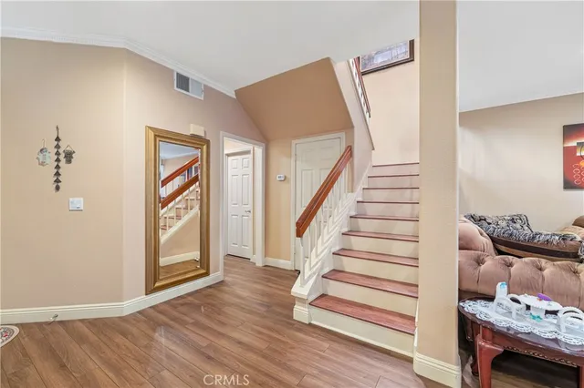 a view of a livingroom with wooden floor and stairs