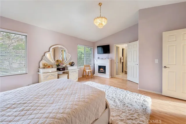 a bedroom with a bed a fireplace and a large window