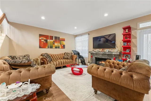 a living room with furniture a flat screen tv and a fireplace