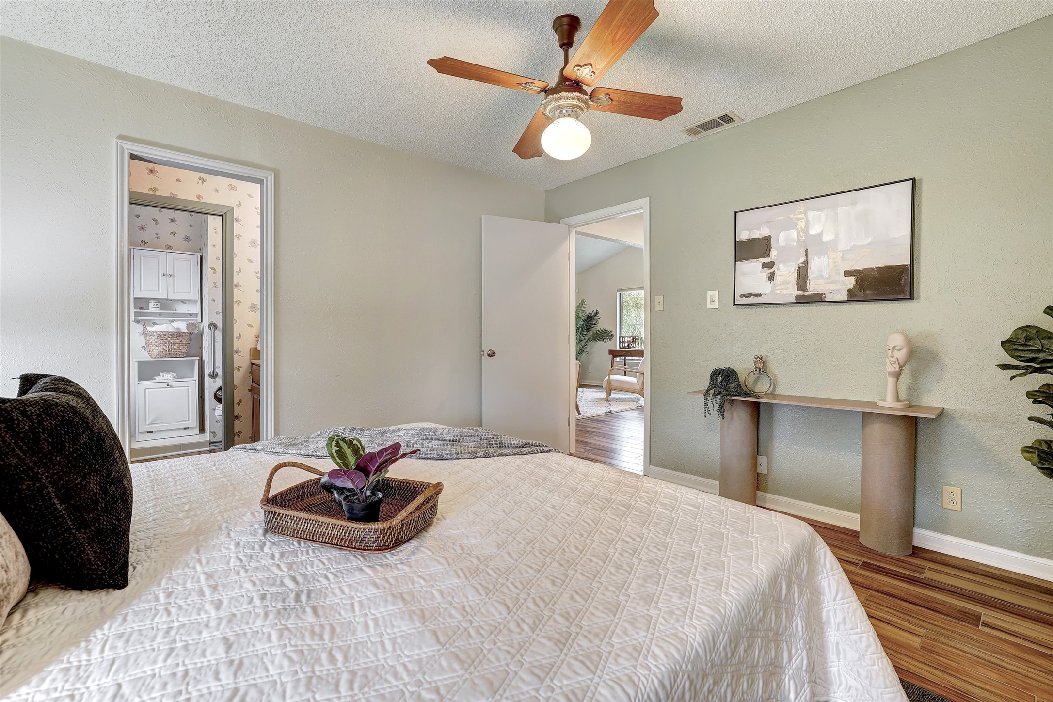 8606 Thunderbird Road, Unit A & B Austin, TX 78736 - Photo 17 of 29 Bedroom with a textured ceiling, a ceiling fan, wood finished floors, and ensuite bath