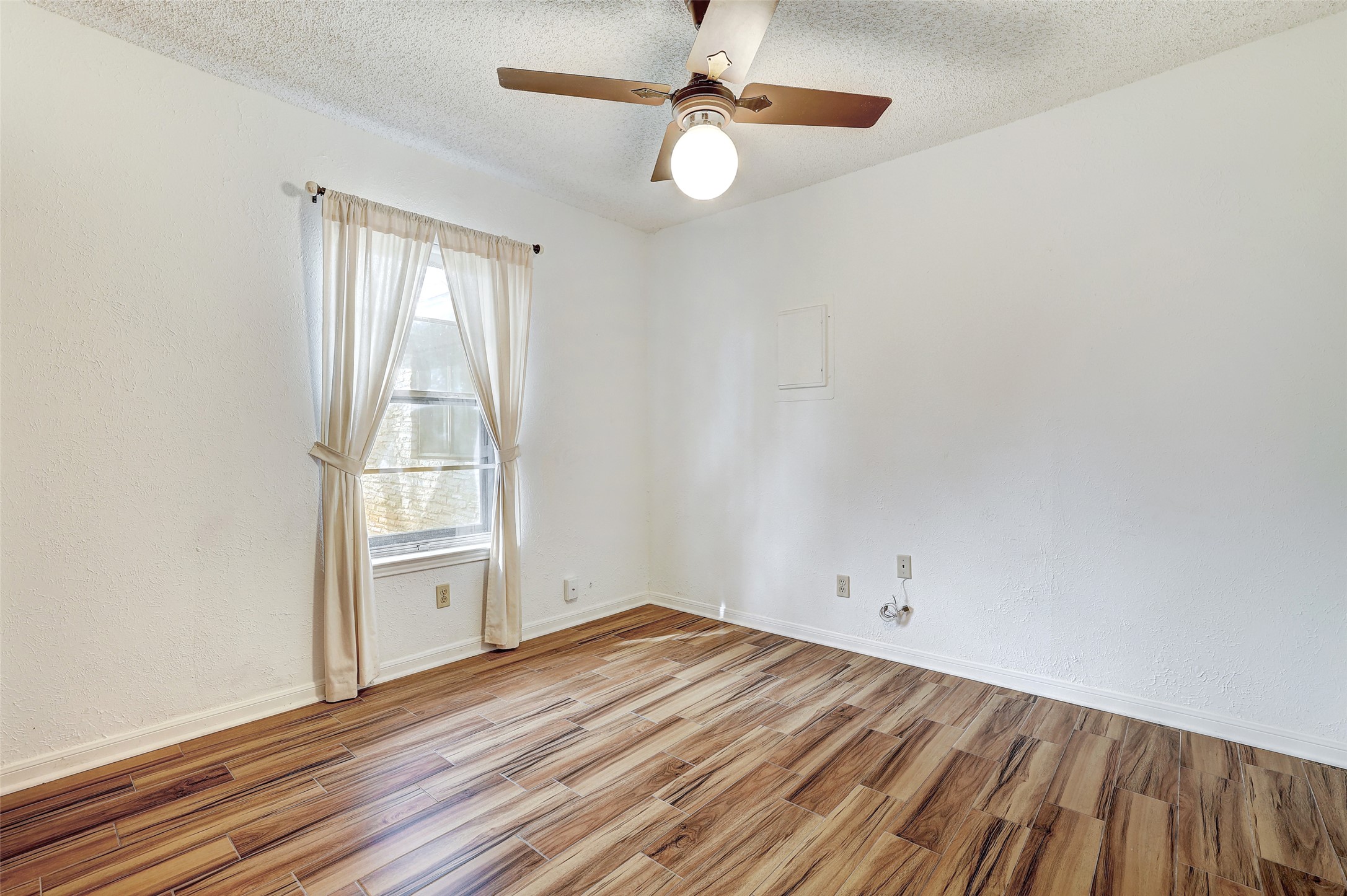 8606 Thunderbird Road, Unit A & B Austin, TX 78736 - Photo 23 of 29 Spare room featuring light wood finished floors, a ceiling fan, and a textured ceiling