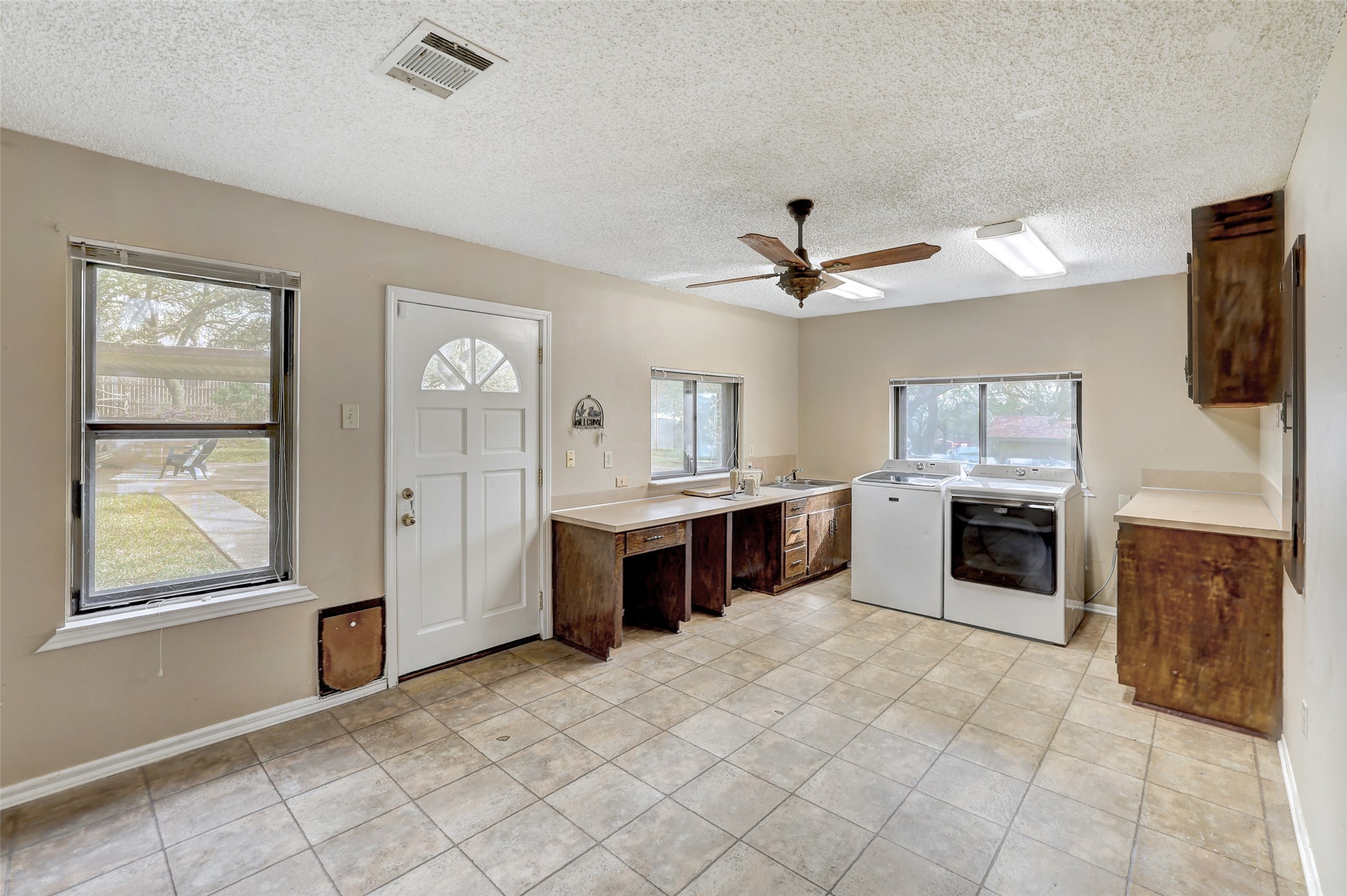 8606 Thunderbird Road, Unit A & B Austin, TX 78736 - Photo 29 of 29 Laundry Room featuring ,sink, sewing area, sewing machine, light countertops, a textured ceiling, dark brown cabinetry, washing machine and dryer, and ceiling fan