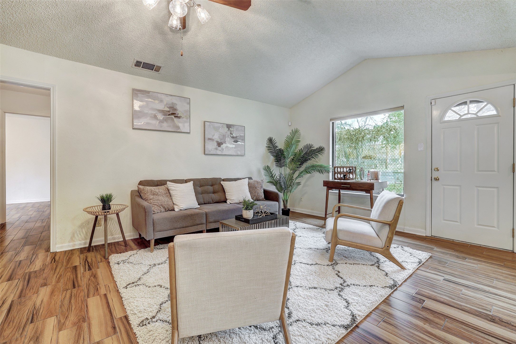 8606 Thunderbird Road, Unit A & B Austin, TX 78736 - Photo 3 of 29 Living area featuring a textured ceiling, ceiling fan, lofted ceiling, and light wood-type flooring