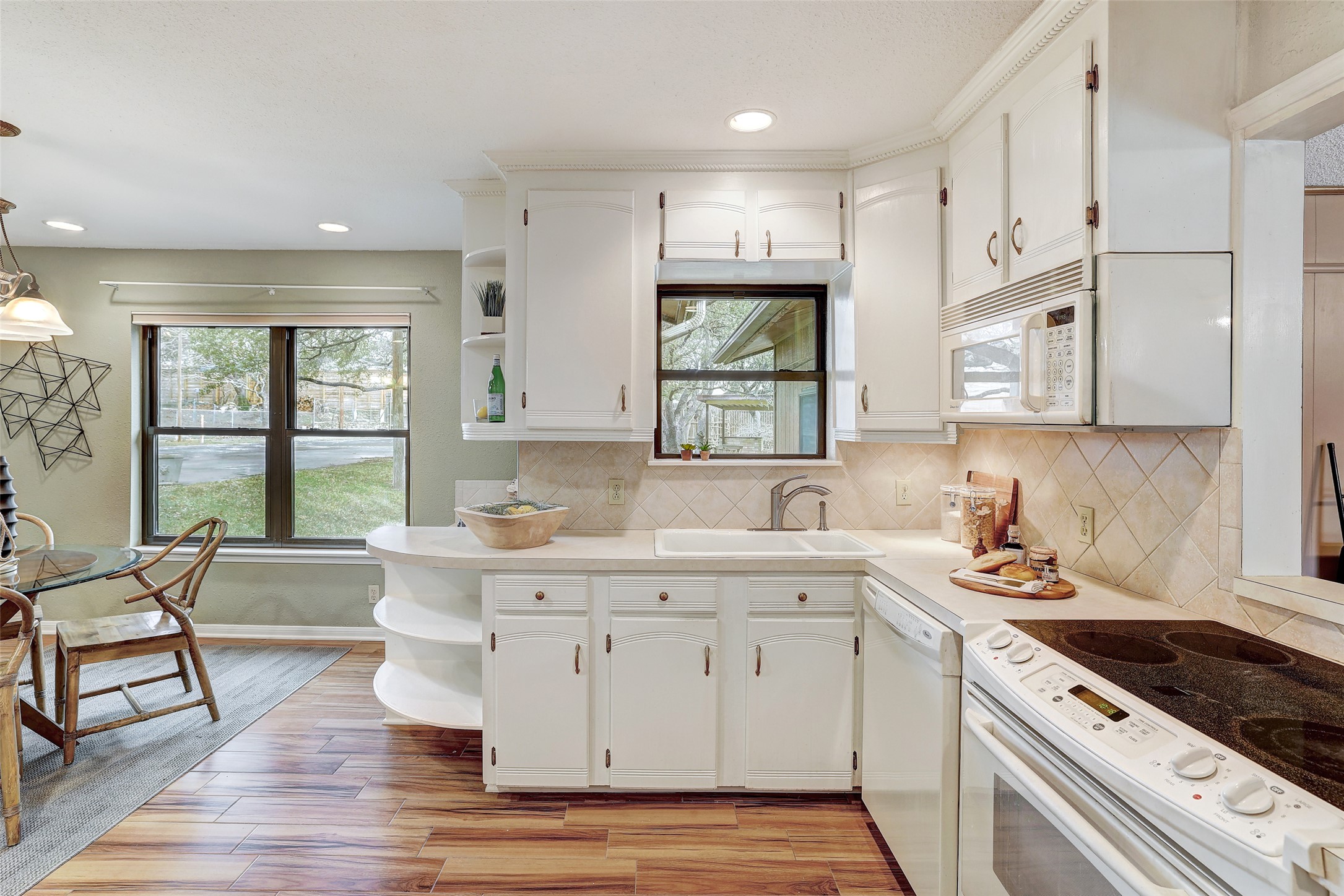 8606 Thunderbird Road, Unit A & B Austin, TX 78736 - Photo 9 of 29 Kitchen featuring open shelves, white appliances, light countertops, white cabinetry, and plenty of natural light