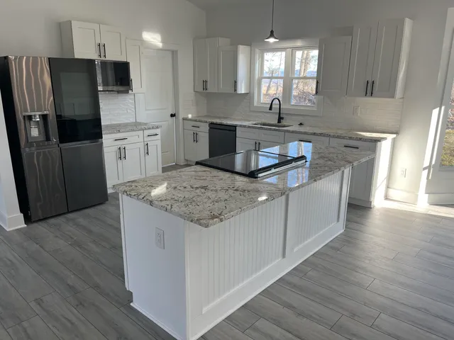 a kitchen with stainless steel appliances granite countertop a sink stove and refrigerator