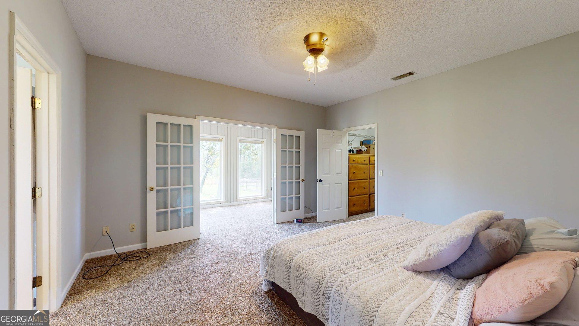 1717 Grady Saunders Road Portal, GA 30450 - Photo 21 of 41 a bedroom with a bed and a chandelier