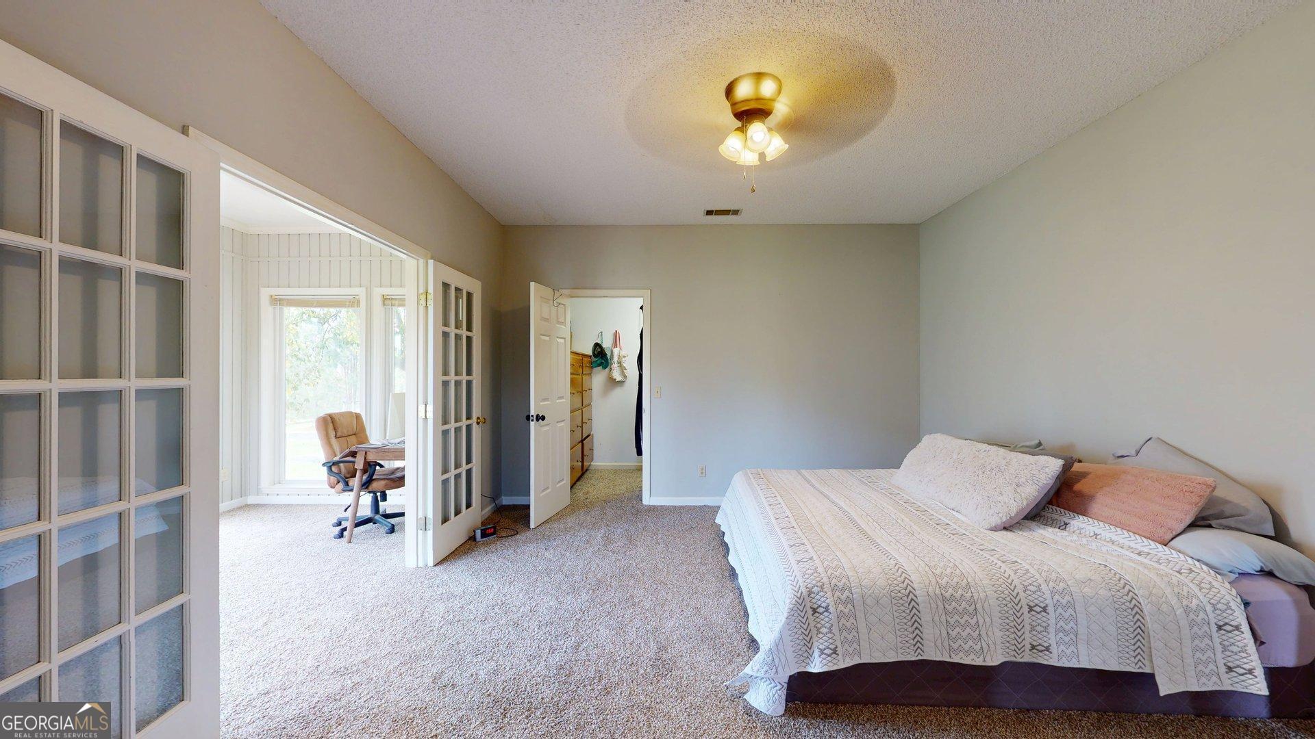1717 Grady Saunders Road Portal, GA 30450 - Photo 22 of 41 a bedroom with a bed and a chandelier