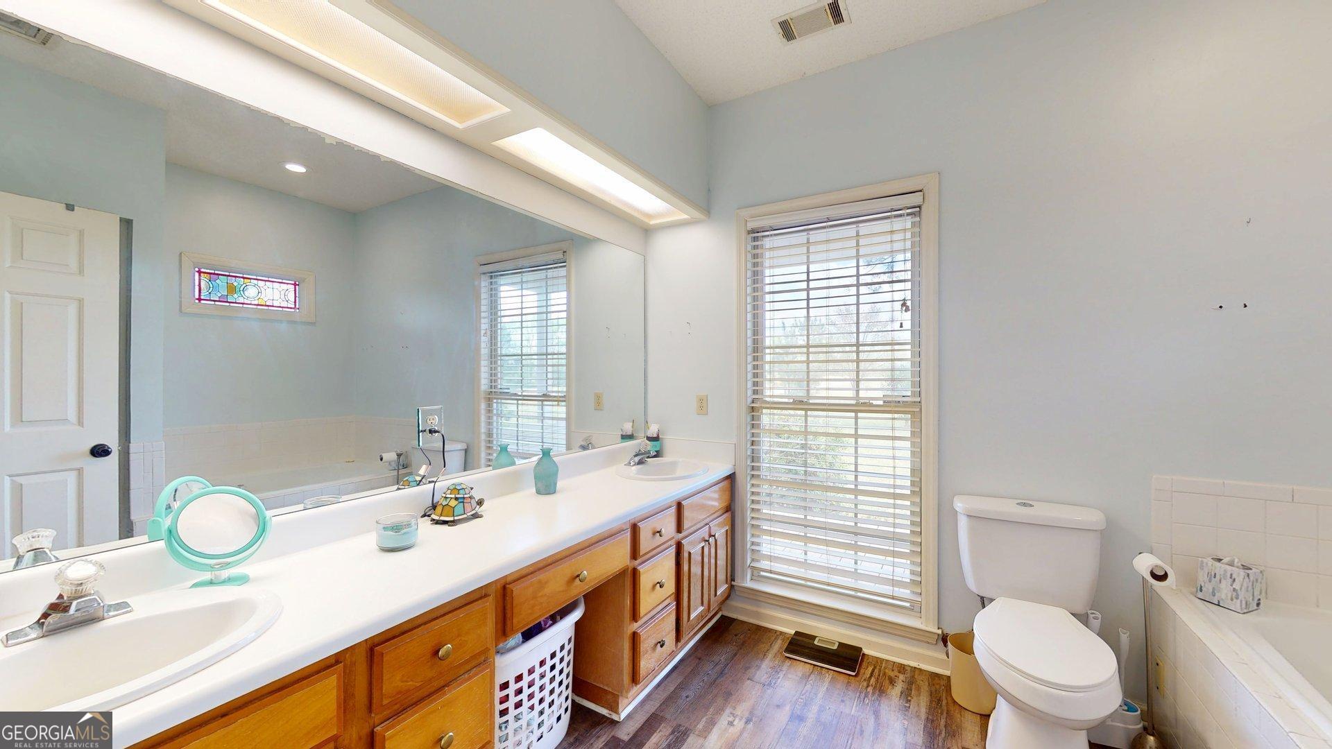 1717 Grady Saunders Road Portal, GA 30450 - Photo 26 of 41 a bathroom with a double vanity sink toilet mirror and shower