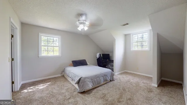 a spacious bedroom with a bed and a window