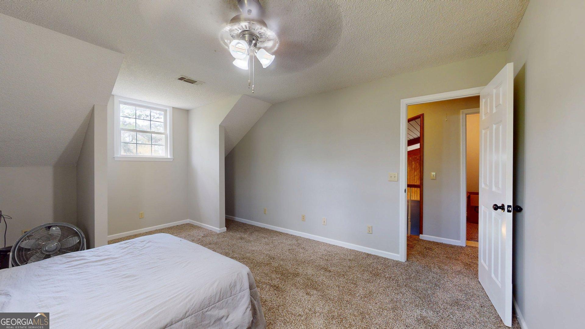 1717 Grady Saunders Road Portal, GA 30450 - Photo 34 of 41 a bedroom with a bed and a chandelier