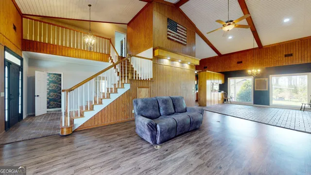 a hallway with couches and large windows with wooden floor