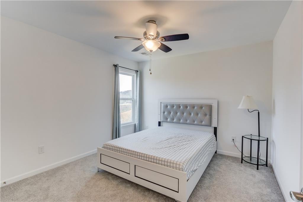 1810 Primrose Park Road Sugar Hill, GA 30518 - Photo 36 of 51 a bedroom with a bed and a chandelier