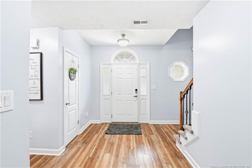 212 Lennox Loop Raeford, NC 28376 - Photo 5 of 47 a view of a hallway with wooden floor and staircase