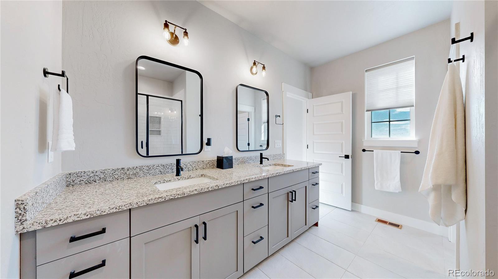 275 Dipper Court Berthoud, CO 80513 - Photo 15 of 34 a spacious bathroom with a granite countertop sink mirror and double