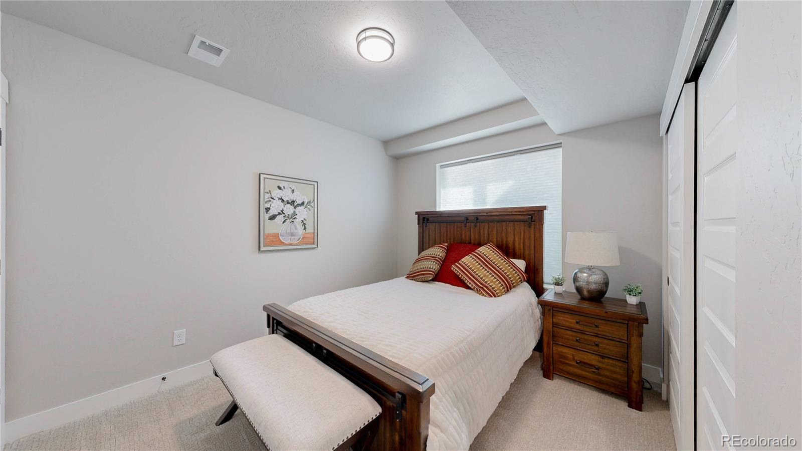 275 Dipper Court Berthoud, CO 80513 - Photo 26 of 34 a bedroom with a bed and a lamp on dresser