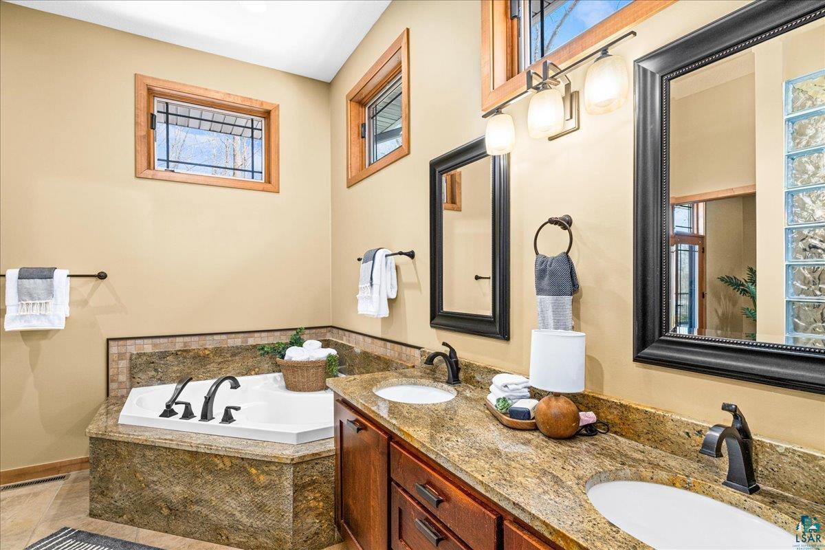 92598 Spells Road Sturgeon Lake, MN 55783 - Photo 25 of 60 Bathroom with a bath and double vanity