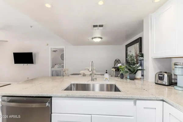 a kitchen with sink and white cabinets
