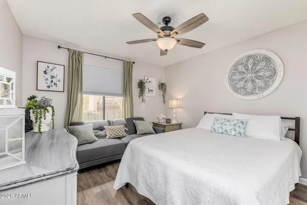 a bedroom with a bed a couch and a chandelier