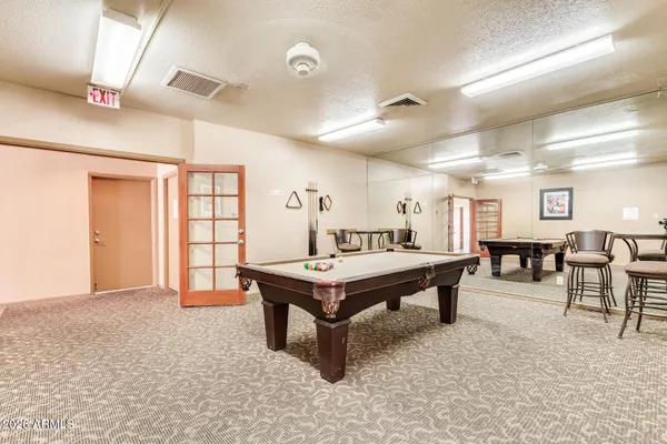 a room with furniture pool table and windows