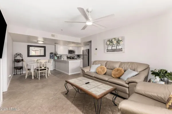a living room with furniture and a dining table with kitchen view